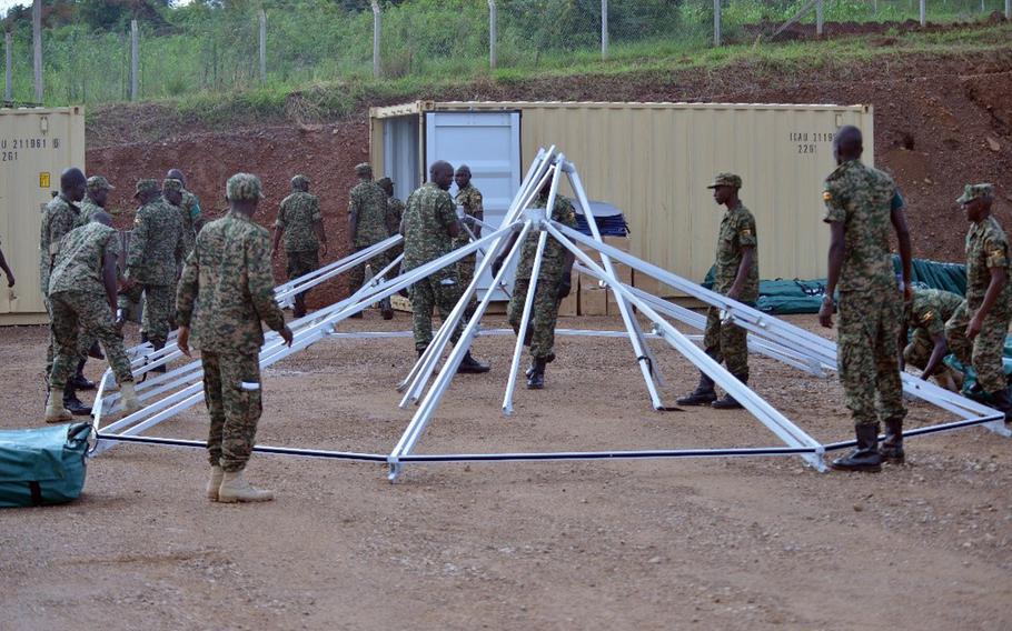 Ugandan soldiers set up the frame of a mobile medical facility at the Uganda Rapid Deployment Capabilities Center in Jinja, Uganda, May 13, 2019, as a part of training under the African Peacekeeping Rapid Response Partnership program. The U.S. has delivered mobile hospitals to Uganda and two other African nations. The units are now being used to treat coronavirus patients.