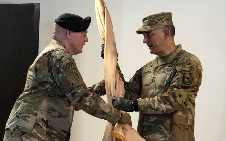 Maj. Gen. Michael D. Turello, left, outgoing commander of Combined Joint Task Force-Horn of Africa, passes the command guidon to Gen. Stephen J. Townsend, commander of U.S. Africa Command, during a socially distanced change-of-command ceremony, June 8, 2020, at Camp Lemonnier, Djibouti. Turello relinquished command to Maj. Gen. Lapthe C. Flora.