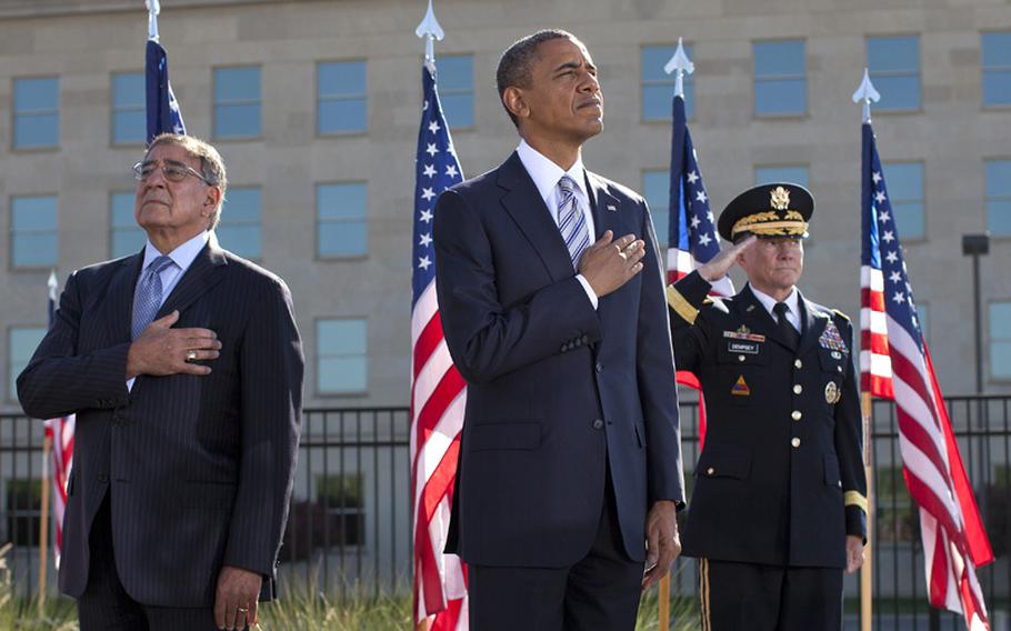 President Barack Obama, flanked by Defense Defense Leon Panetta, left, and Joint Chiefs Chairman Gen. Martin Dempsey, render respect to the flag at the Pentagon Memorial Tuesday, Sept. 11, 2012, during a ceremony to mark the 11th anniversary of the Sept. 11 attacks. 