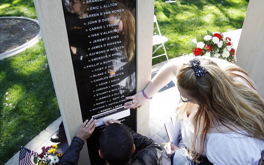 Family members make pencil rubbings of the names of loved ones after the Idaho Fallen Soldier memorial service at the Idaho Fallen Soldier Memorial in downtown Boise, Idaho, Tuesday, September 11 2012.