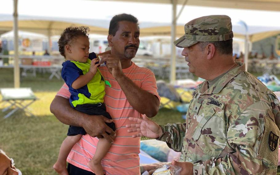 Brig. Gen. Miguel Mendez, the commander of the military's earthquake response mission, visits with residents at one of the five shelters that the Puerto Rico National Guard built to house people who lost their homes during a series of earthquakes. About 1,100 service members are helping with security, food service and medical care at the tent shelters.