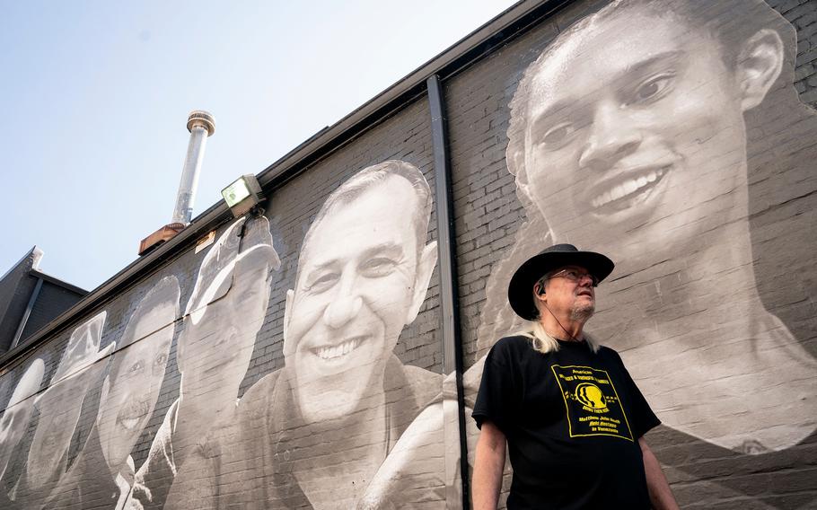 Dr.  Everett Rutherford Jr., el tío de Matthew Heath, un ex marine estadounidense que estuvo detenido en Venezuela durante 22 meses, pasa frente a un mural creado por el artista Isaac Campbell en Washington, DC, el 20 de julio de 2023. 