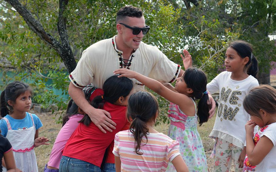 Senior Airman Peter Guy gathers hugs during a visit to Our Lady Guadalupe Children's Home, an orphanage near Soto Cano Air Base, Honduras, on March 8, 2019.