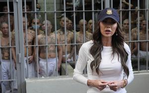 Encarcerated men watch from a prison cell while a U.S. official speaks in El Salvador.