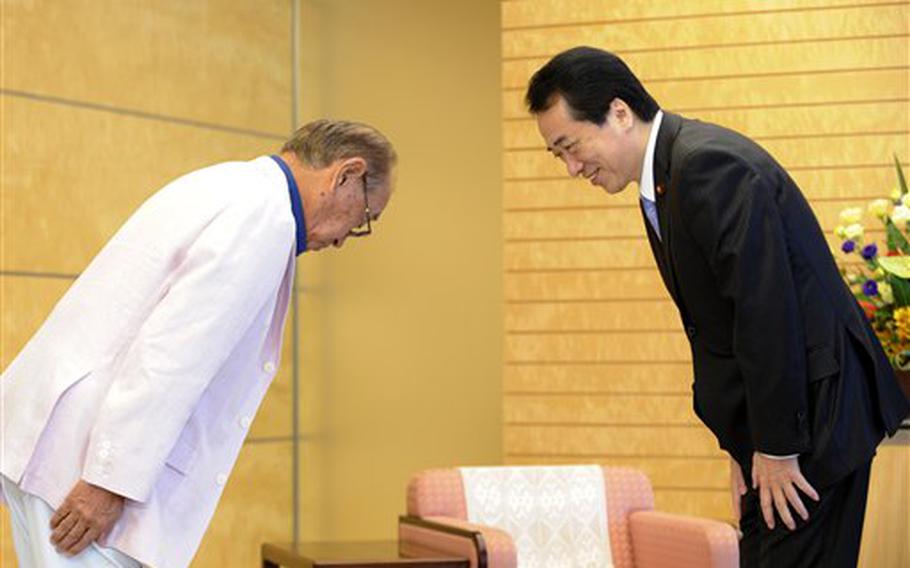 Japanese Prime Minister Naoto Kan, right, and Okinawa Governor Hirokazu Nakaima exchange bows Tuesday as they have talks at Kan's official residence in Tokyo.