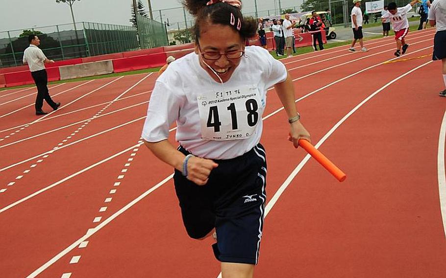 A Special Olympics athlete races past the finish line with a broad smile on her face after securing second place for her team in the 400m relay race at the Kadena Special Olympics on Saturday.