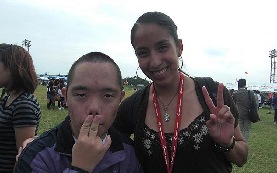 Takashi Oshiro, 20, from Naha, and his escort, Marine Lance Cpl. Elena Jaramillo of Marine Corps Air Station Futenma, are ready to participate in the tennis event during the Kadena Special Olympics on Saturday at Kadena Air Base.