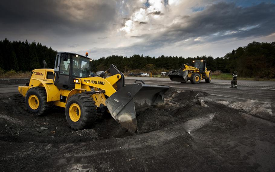 Front-end loaders from the 35th Civil Engineer Squadron airfield damage repair flight clear debris after a simulated missile impact Monday during an operational readiness exercise at Misawa Air Base, Japan. The mock runway area gives the flight the ability to practice its craft without damaging the active runway or taxiways. 