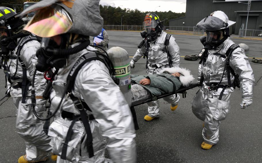 Base firefighters remove a 'victim' from the scene of a simulated accident and fuel truck spill Tuesday during a training exercise at Misawa Air Base, Japan.