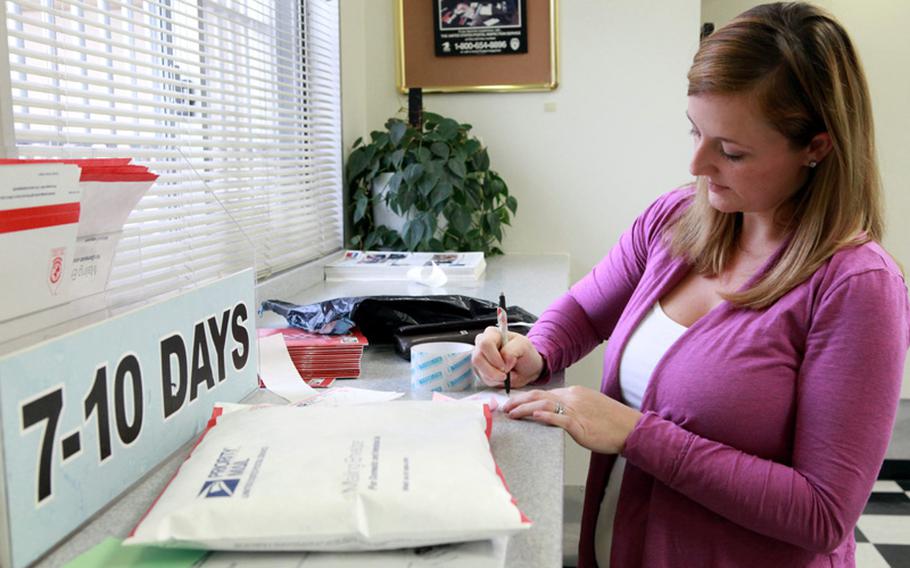 Krista Whipple, a military dependent at Yokota Air Base, Japan, fills out a shipping label as she tries to beat the Christmas rush at the base post office. Throughout the Pacific residents are flocking to post offices to mail their holiday packages to loved ones in the U.S.