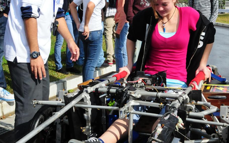 Abagail Crouson, a Kubasaki High School 10th-grader, carefully gets out of the solar powered vehicle after taking it for a quick spin around a closed circuit track at Kubasaki High School Friday morning.