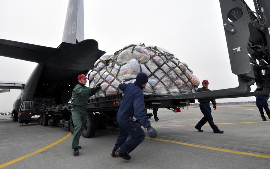 Japan Air Self-Defense Force personnel and contracted workers help move a pallet of donated blankets off of a U.S. Navy C-130 at Misawa Air Base, Japan.  The Navy air crew picked up the donations at Marine Corps Air Station Iwakuni, Japan, and brought them to Misawa as part of humanitarian relief efforts in earthquake- and tsunami-ravaged northeastern Japan.
