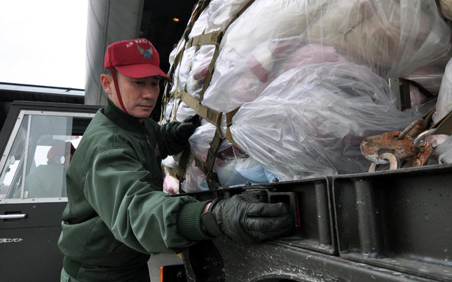 First Sgt. Yoshihiro Kamamoto, a member of the Japan Air Self-Defense Force, helps unload a pallet of donated blankets from a U.S. Navy C-130 on Sunday at Misawa Air Base, Japan. Hundreds of thousands of pounds of goods have poured into the base as officials here have ramped up humanitarian relief efforts in Japanese communities hard hit by a deadly and devastating earthquake and tsunamis that pounded the northeastern part of the country on March 11. 
