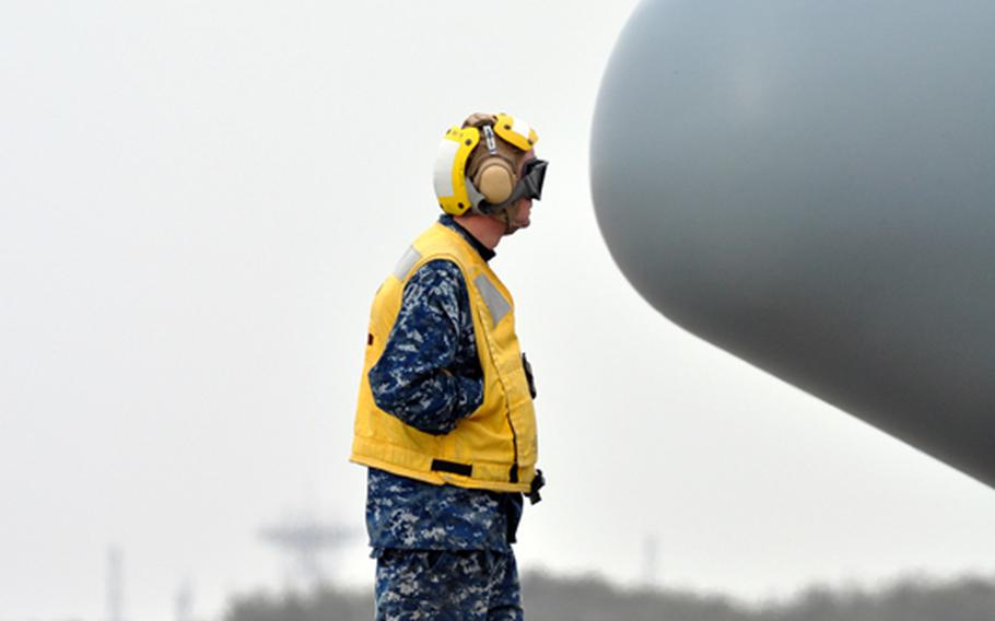 Petty Officer 2nd Class Justin Landers waits as humanitarian relief supplies are unloaded from a Navy C-130 at Misawa Air Base, Japan, on Sunday. Hundreds of thousands of pounds of goods have poured into the base as officials there have ramped up humanitarian relief efforts in Japanese communities hard hit by a deadly and devastating earthquake and tsunamis that pounded the northeastern part of the country on March 11. 
