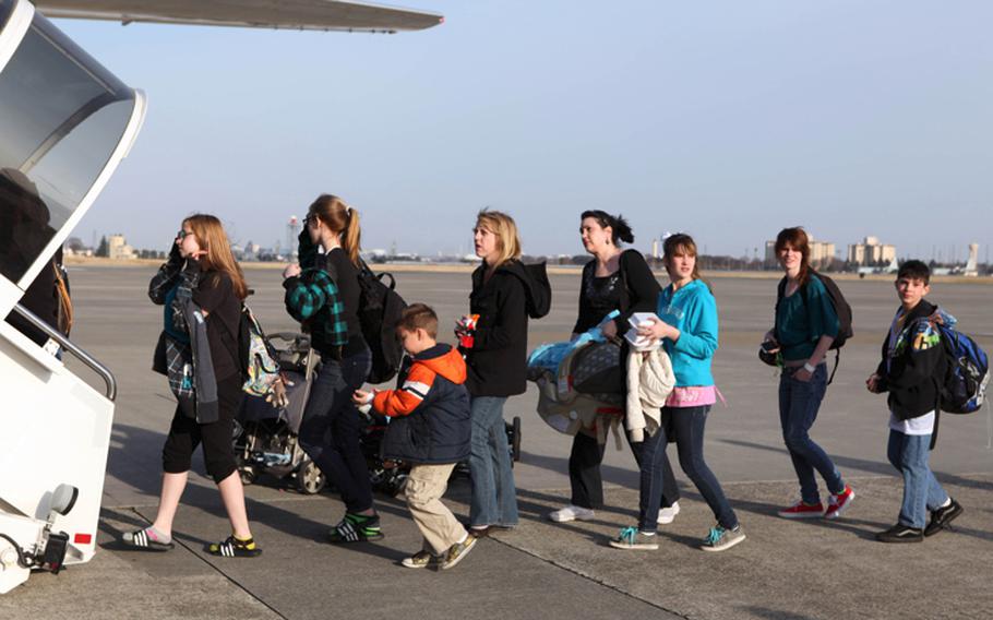 U.S. military family members board a flight from Yokota Air Base, Japan, to Seattle on March 19.