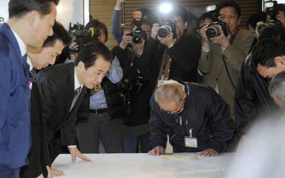 TOKYO, Japan - Prime Minister Naoto Kan (L) bows during a meeting at his office in Tokyo on April 5, 2011, with the mayors of local municipalities near a crisis-hit nuclear power plant in Fukushima Prefecture. Kan promised that the government will bear ultimate responsibility in the ongoing nuclear crisis, with the local chiefs calling for maximum state assistance.