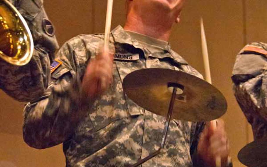 Sgt. David Simmons, 29, the drummer for the Camp Zama Army Band, plays along with 14 other band mates at the Rokugo Middle School shelter in Sendai City.