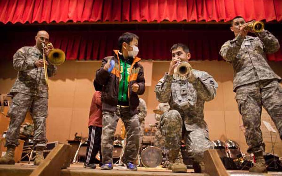 Children at the Rokugo Middle School shelter in Sendai City dance on stage with the Camp Zama Army Band that played a concert for the residents.