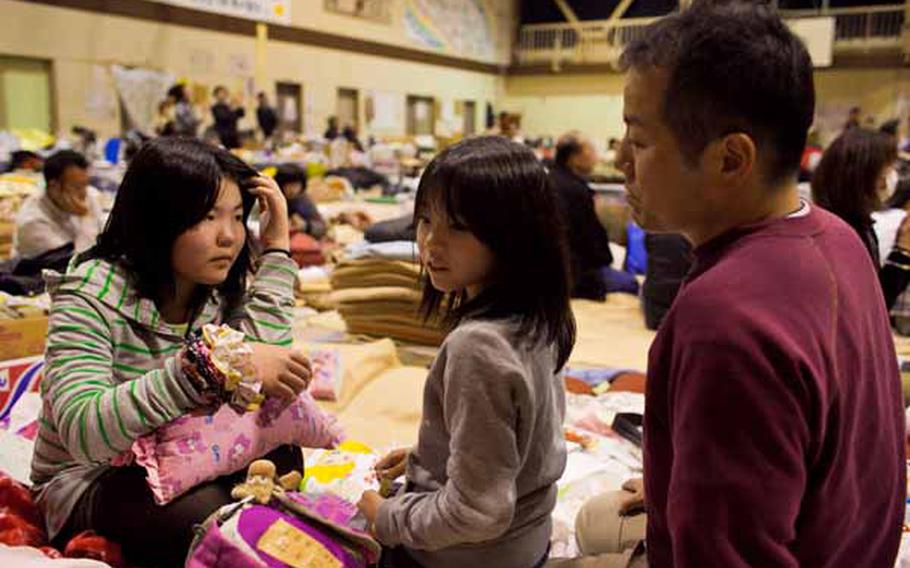 Hiromi Sato, right, along with his daughters, Ami, 8, center, and Natsuki, 11, said they enjoyed the concert from the Camp Zama Army Band at the Rokugo Middle School shelter in Sendai City.