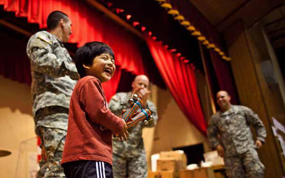 A boy at the Rokugo Middle School shelter in Sendai City dances on stage with the Camp Zama Army Band that played a concert for the residents.