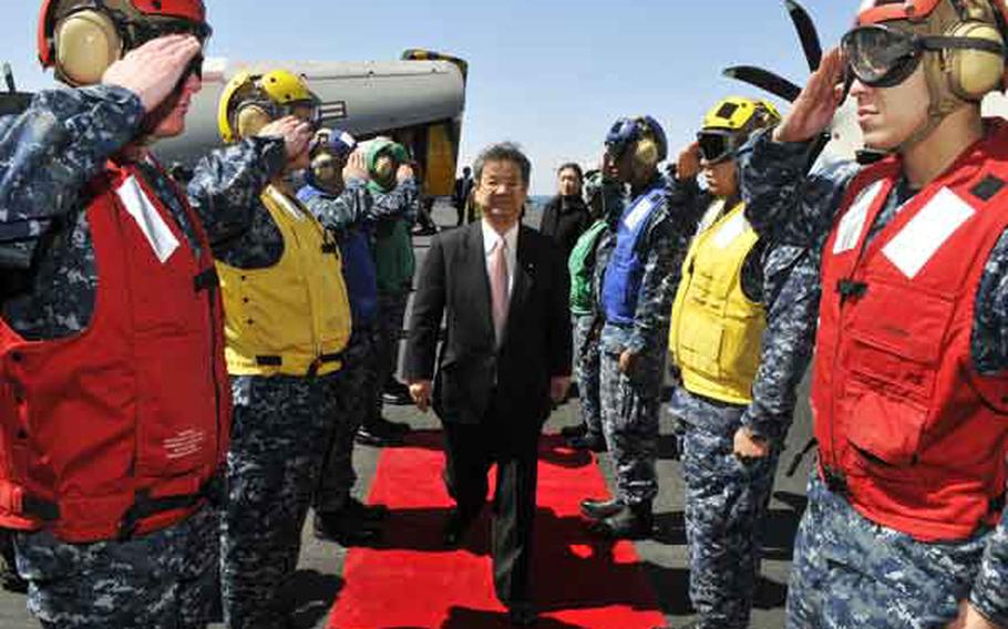 U.S. sailors salute Japan's Defense Minister Toshimi Kitazawa upon his arrival aboard the aircraft carrier USS Ronald Reagan in the Pacific Ocean last week. During the visit, Kitazawa thanks U.S. troops for their relief efforts. 