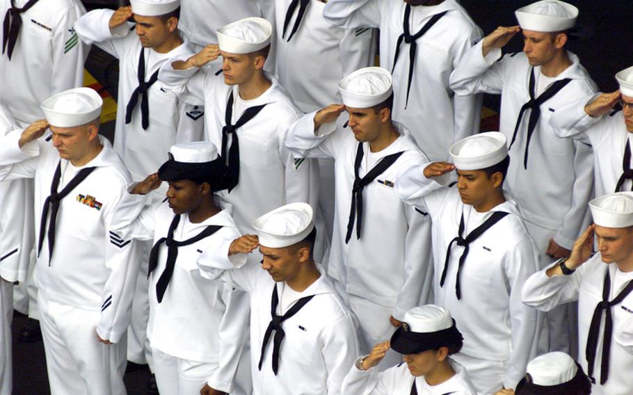 Sailors render honors during a burial at sea ceremony aboard USS John C. Stennis (CVN 74).  Committing to the sea cremated remains of honorably discharged military personnel is performed aboard U.S. Navy ships at the request of the deceased's family. 