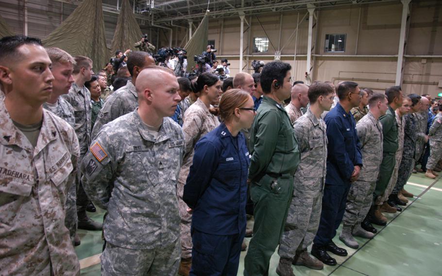 Defense Secretary Leon Panetta speaks to about 150 servicemembers in a hangar at Yokota Air Base, Japan on Oct. 24, 2011, saying he would shield their benefits from DOD fiscal reality. About 100 Japanese troops also attended the town hall meeting.