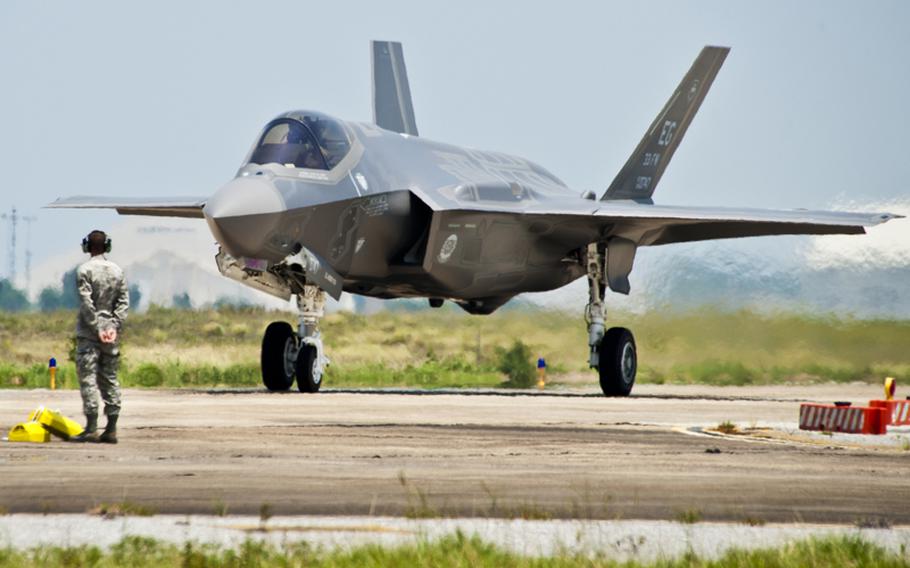 A 33rd Fighter Wing maintainer watches as the first F-35 Lightning II joint strike fighter taxis in to its new home at Eglin Air Force Base, Fla., July 14, 2011.

