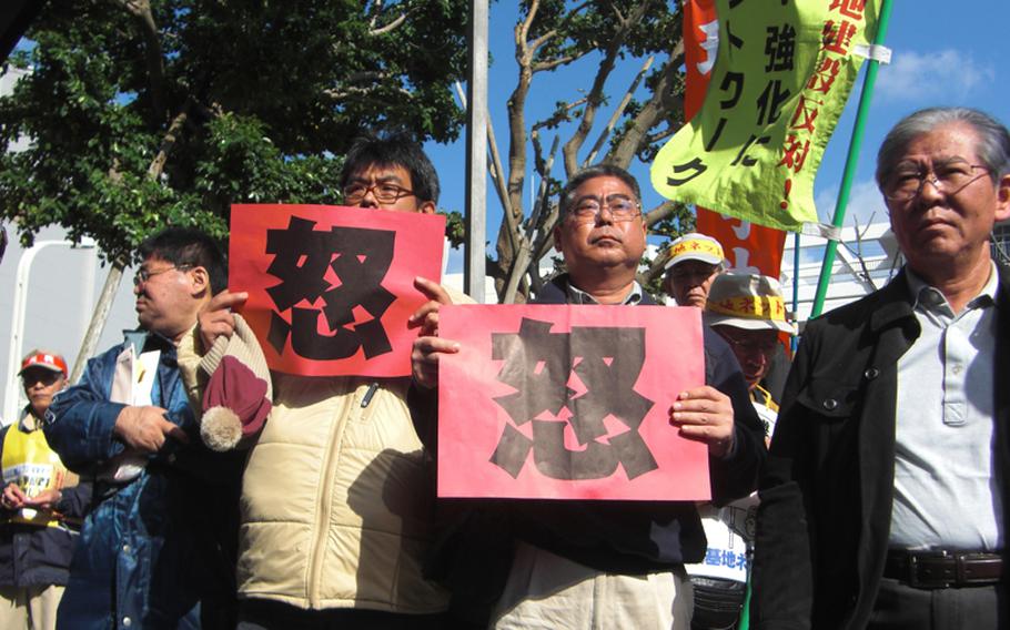 Holding cards that read 'wrath' in Chinese, protesters assemble for a second day on Dec. 28, 2011, at Okinawa prefectural office in an attempt to block a controversial environmental assessment report from being submitted to Okinawa government.