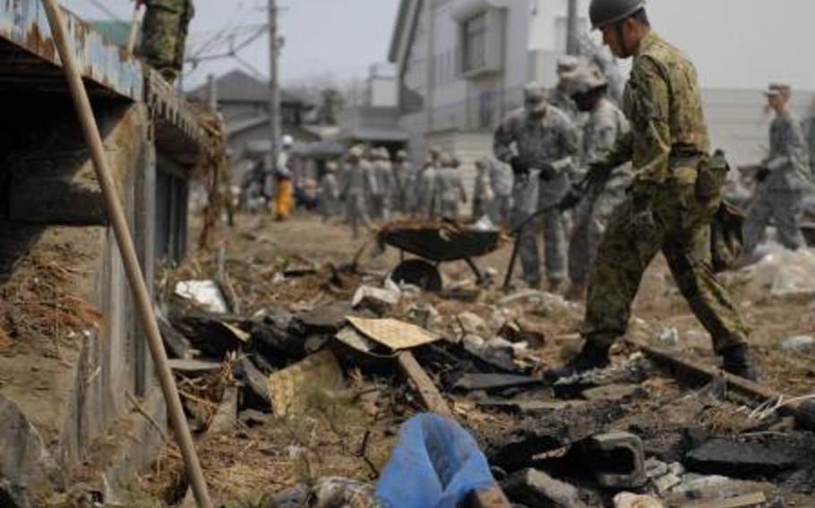 Japanese and U.S. servicemembers remove debris from railroad tracks in the Tohoku region of Japan on April 21, 2011. The effort was in support of Operation Soul Train. The region is struggling with debris left after the massive tsunamis, and plans to burn some of it in Okinawa is drawing heat from concern citizens. Some city governments on Okinawa are rejecting a proposal to help dispose of disaster debris from northeastern Japan amid radiation fears.