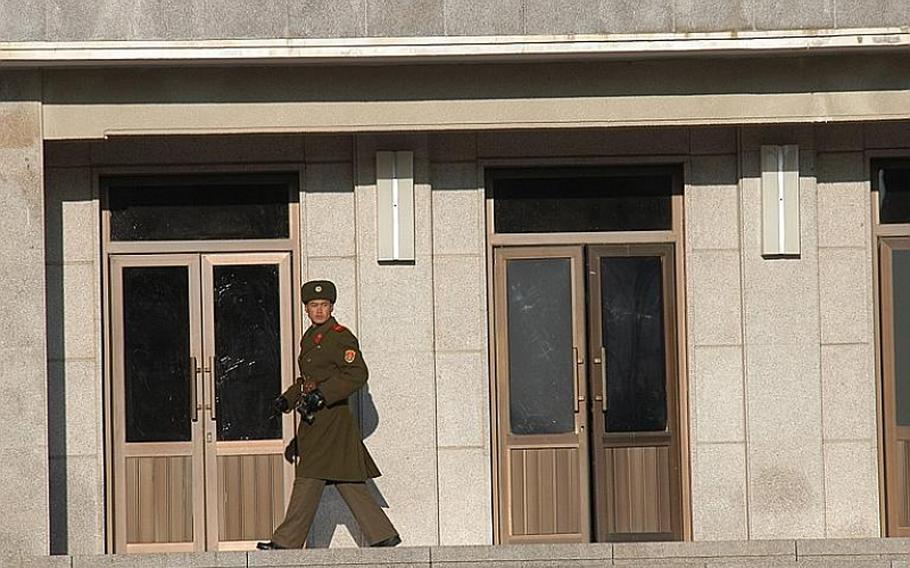 A North Korean soldier, binoculars in hand, keeps an eye on the South Korean side of the Joint Security Area of the Demilitarized Zone on Dec 22, 2011. After its failed attempt to launch a rocket April 13, 2012, some believe North Korea is planning a nuclear test.