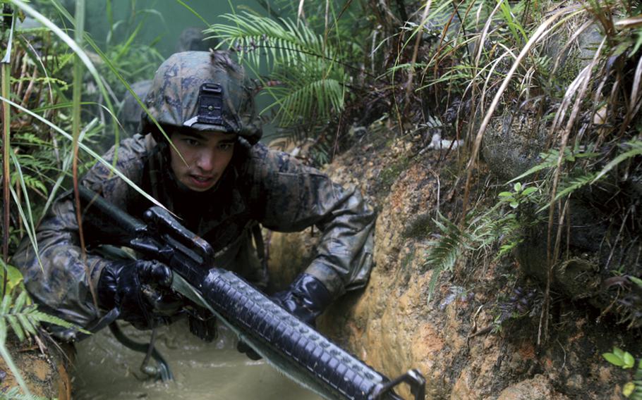 In this 2010 file photo, Cpl. Mario Sanchez, an amphibious assault vehicle crewman with 3rd Assault Amphibian Battalion, 1st Marine Division, I MEF, deployed to Okinawa and attached to Combat Assault Battalion, 3rd Marine Div., III MEF, navigates through the Jungle Skills Course at the Jungle Warfare Training Center.