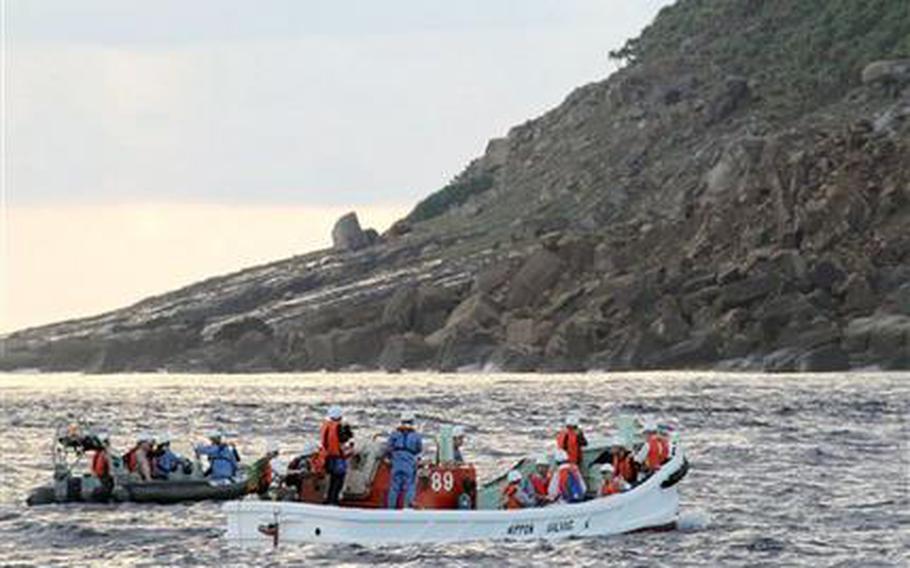 Tokyo city officials and experts survey Uotsuri Island, one of the islands of Senkaku in Japanese and Diaoyu in Chinese, in the East China Sea early Sunday, Sept. 2, 2012. Tokyo city officials planning to buy tiny islands at the center of a longtime territorial dispute with China surveyed the area and took water samples Sunday in a showcase meant to send a message of ownership. 