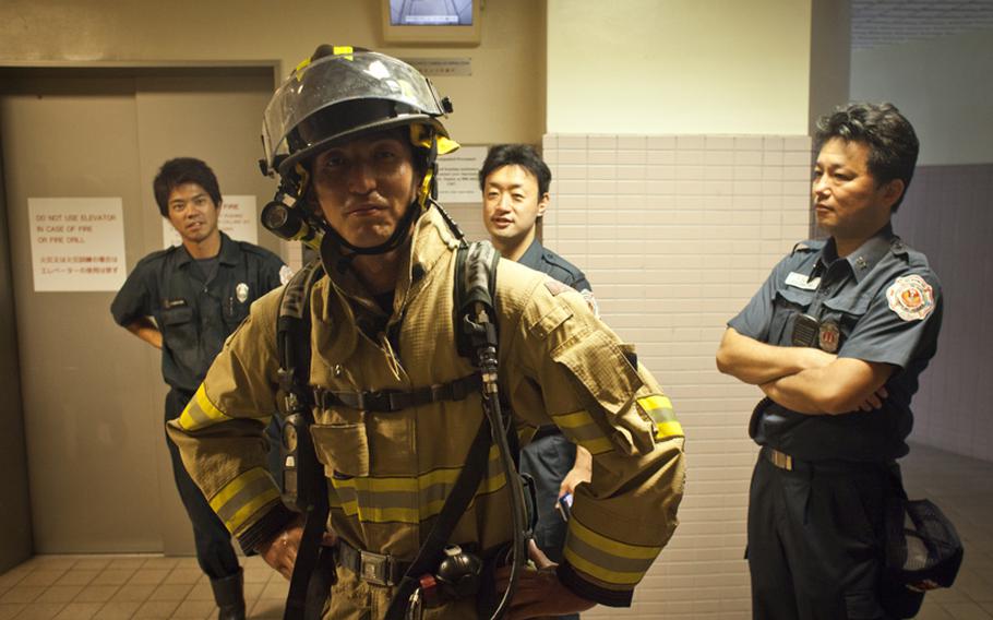 A firefighter from Naval Air Facility Atsugi, Japan poses after climbing 110 flights of stairs during a memorial stair climb at an on-base housing tower to honor the first responders of the Sept. 11, 2001, terrorist attack who lost their lives when the towers collapsed. 