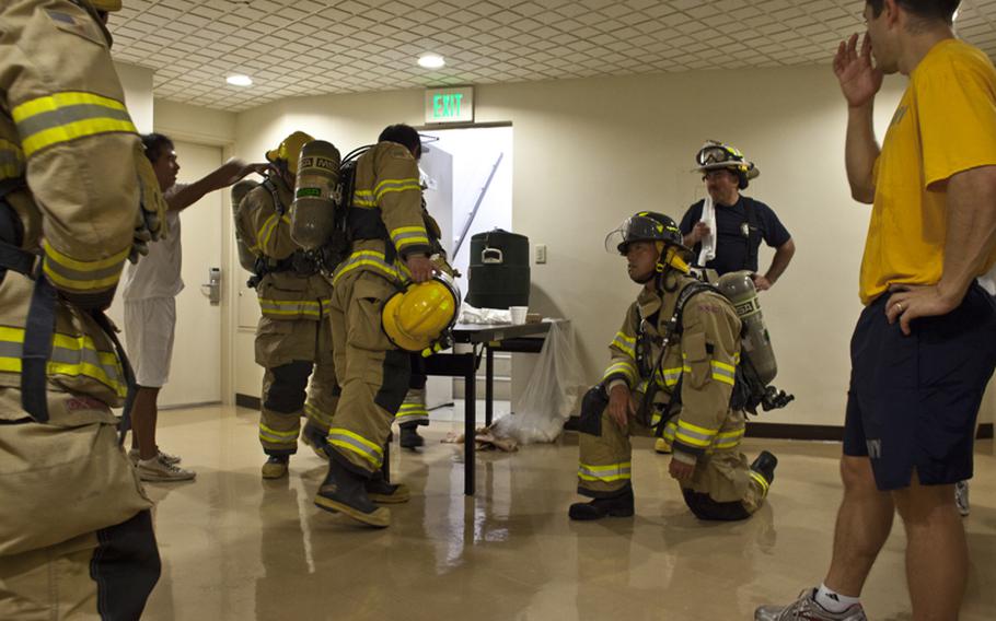 Firefighters from Naval Air Facility Atsugi, Japan, rest at the top floor of an on base housing tower during a memorial stair climb on Sept. 11, 2012. To honor the first responders of the Sept. 11 terrorist attack, more than 40 firefighters, medical personnel and security forces climbed 110 flights of stairs, the same number as the towers that fell on Sept. 11, 2001. The event commemorated the sacrifice of the emergency workers who died when the towers fell.
