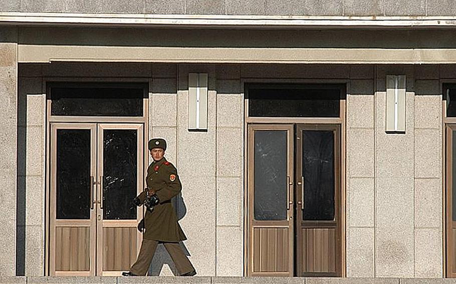 An unidentified North Korean soldier, binoculars in hand, keeps an eye on the South Korean side of the Joint Security Area of the Demilitarized Zone on Dec 22, 2011. On Oct. 6, 2012, a North Korean soldier killed two of his officers and defected to South Korea. 