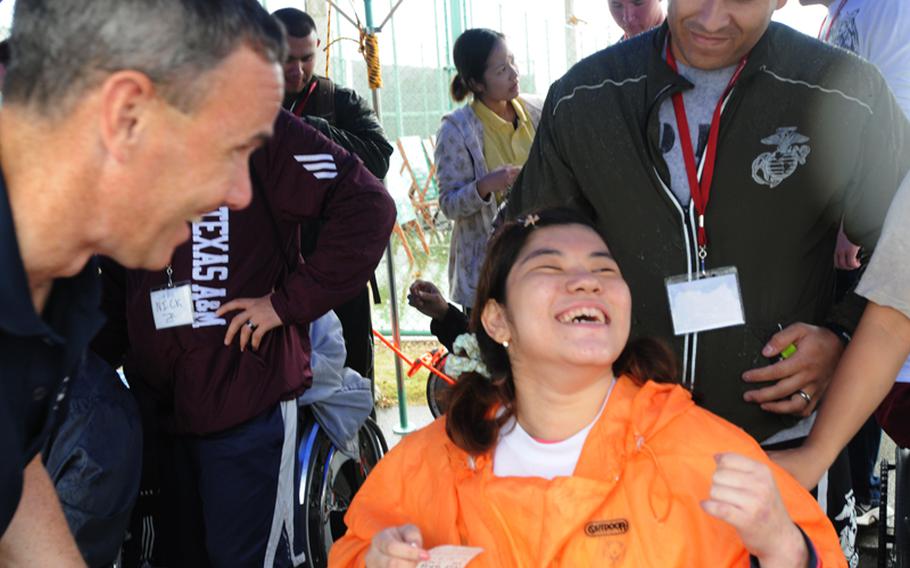 Nanami Tamayose smiles in relief after reading an English message she prepared to Capt. Richard Weathers, commanding officer of the Fleet Activities Okinawa. 
For Tamayose, the annual Kadena Special Olympics is something she is looking forward to every year. 
She participates in wheelchair softball throw Saturday. 
About 900 special-needs athletes compete in the various games, while nearly 3,000 American and Japanese volunteers support the special event at Kadena Air Base Saturday.