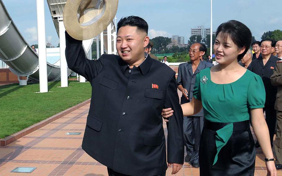 In this July 25, 2012, photo released by the Korean Central News Agency and distributed in Tokyo by the Korea News Service, North Korean leader Kim Jong Un, accompanied by his wife Ri Sol Ju, waves to the crowd as they inspect the Rungna People's Pleasure Ground in Pyongyang, North Korea.