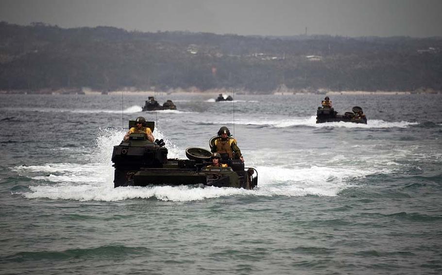 Marines with the III Marine Expeditionary Force maneuver amphibious assault vehicles through the water in formation March 5, 2013,  at Camp Schwab on Okinawa, where the Futenma air station is slated to be moved. 
