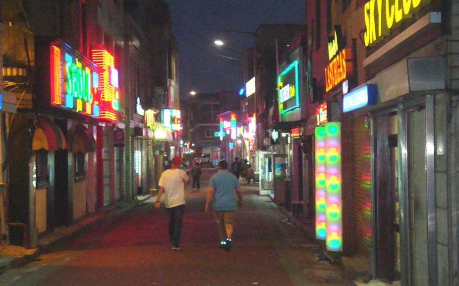 U.S. servicemembers walk down the main street of The Ville, the entertainment district just outside the front gate of Camp Casey in South Korea. Four U.S. soldiers were injured on March 16, 2013, in a brawl that involved a knife and baseball bat.