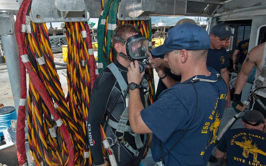 Chief Petty Officer Jeremiah Lively, assigned to the submarine tender USS Frank Cable, performs a safety check on Petty Officer 3rd Class Robert Dotzler's diving equipment on Sept. 3, 2012, at Subic Bay, Philippines.  