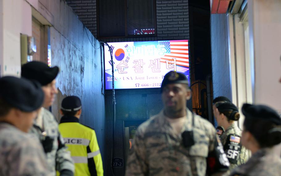 Members of the Osan Air Base joint town patrol pause to discuss what they had seen in front of the Shinjang Shopping Mall, just outside the front gate of the base in South Korea, March 16, 2013. The patrol includes members of the 51st Security Forces Squadron and South Korean police.