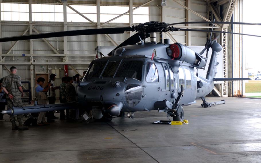 Japanese media gather around a HH-60 Pave Hawk helicopter during a press conference on the safety of the aircraft at Kadena Air Base, Okinawa, Aug. 14, 2013. 