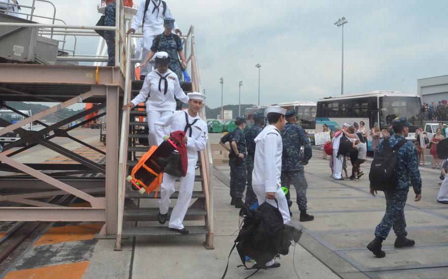 Sailors carry their gear as they disembark the aircraft carrier USS George Washington at Yokosuka Naval Base on Friday. About 5,000 sailors got off the ship, which returned to Yokosuka for a break in its ongoing Western Pacific patrol.
