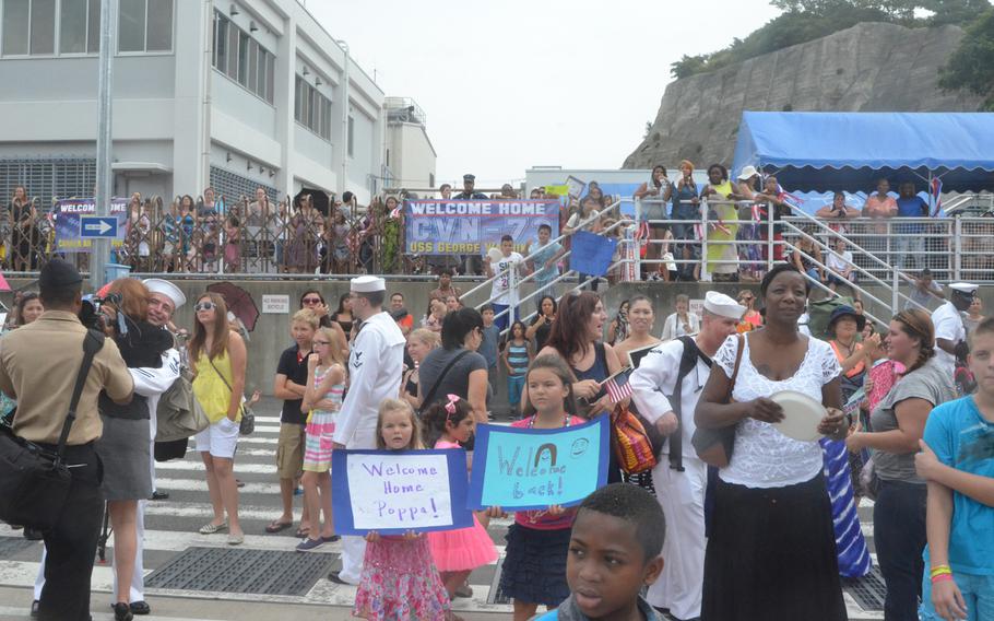 Families await their loved ones as sailors disembark the aircraft carrier USS George Washington at Yokosuka Naval Base on Friday. About 5,000 sailors got off the ship, which returned to Yokosuka for a break in its ongoing Western Pacific patrol.
