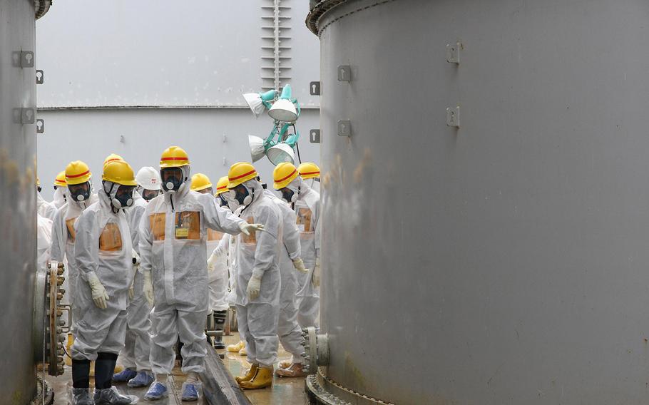 Nuclear Regulation Authority commissioners inspect storage tanks used to contain radioactive water at the Fukushima Dai-ichi nuclear power plant, operated by Tokyo Electric Power Co. in Fukushima prefecture, northern Japan, on Friday, Aug. 23, 2013. 