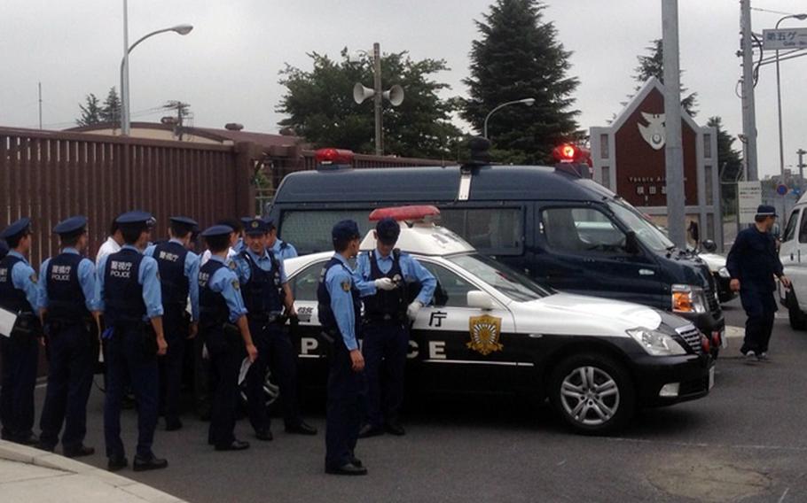 Japanese officers respond to a report of a small explosion outside of a Yokota Air Base gate that forced a lockdown of the facility Saturday, Sept. 7, 2013.