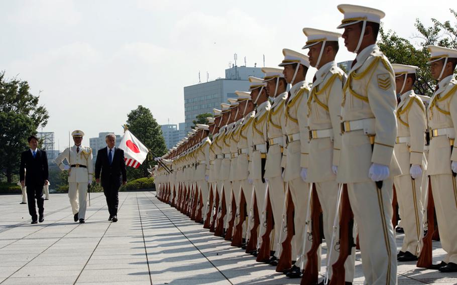 Japanese Defense Minister Itsunori Onodera escorts U.S. Defense Secretary Chuck Hagel, third from left, during a pass-in-review ceremony in Tokyo on Oct. 3, 2013. The two counterparts later met to discuss issues of mutual importance.