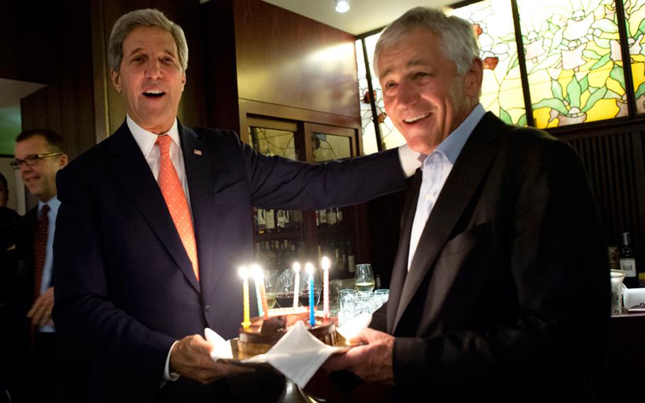 U.S. Secretary of State John F. Kerry, left, surprises U.S. Defense Secretary Chuck Hagel with a birthday cake after meetings with defense and foreign affairs counterparts in Tokyo on Oct. 3, 2013. Hagel’s birthday is Oct. 4.