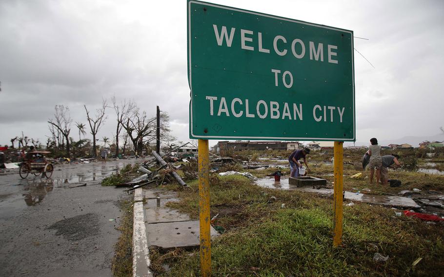 Residents gather water outside damaged houses in Tacloban city, Leyte province central Philippines on Sunday, Nov. 10, 2013. The city remains littered with debris from damaged homes as many complain of shortage of food, water and no electricity since the Typhoon Haiyan slammed into their province. Haiyan, one of the most powerful typhoons ever recorded, slammed into central Philippine provinces Friday leaving a wide swath of destruction and scores of people dead.   